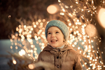 portrait of happy girl in winter evenings on background of christmas lights