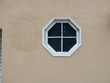 Octagon shaped glass window on the side of beige house