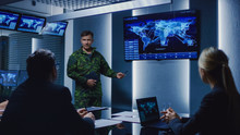 High-Ranking Military Man Holds A Briefing To A Team Of Government Agents And Politicians, Shows Satellite Surveillance Footage. 