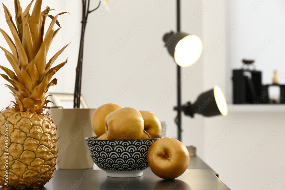 Golden fruits on dark table in room