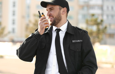 male security guard with portable radio transmitter outdoors