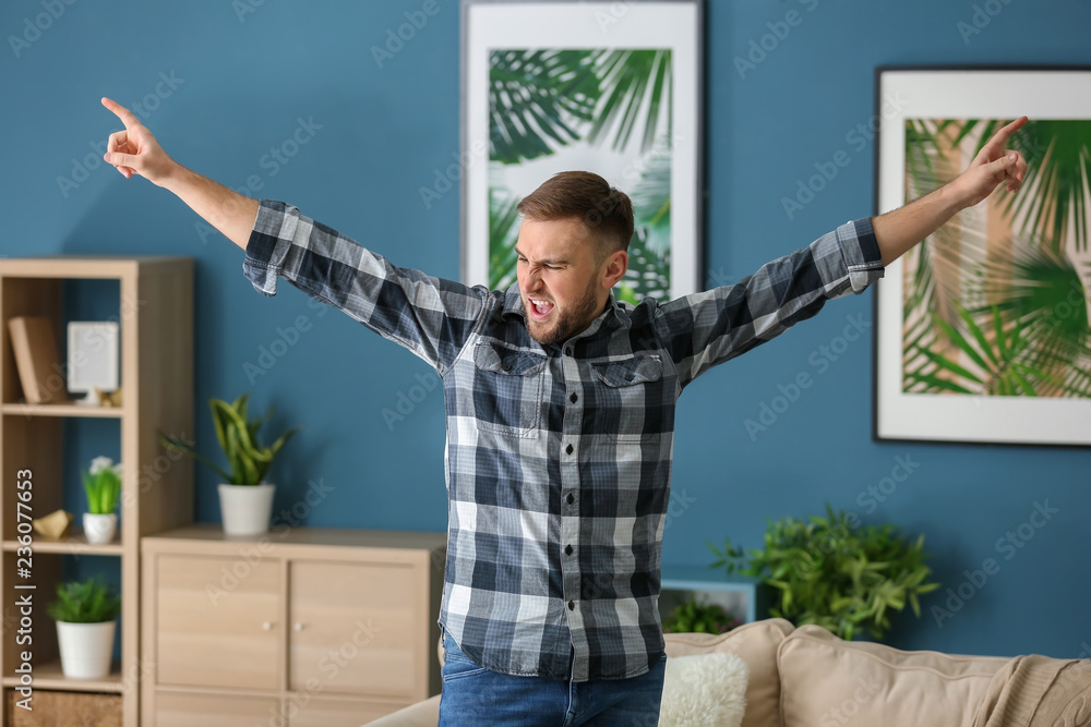 Handsome emotional young man at home