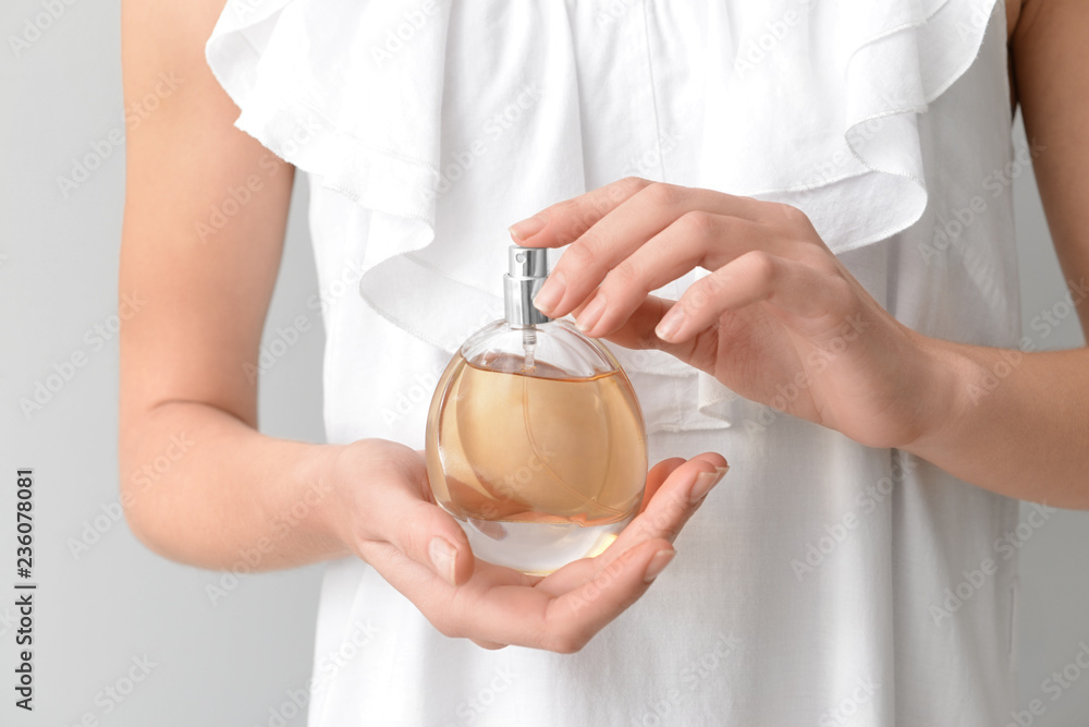 Woman with bottle of aromatic perfume, closeup