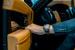 Leinwandbild Motiv cropped image of businessman with luxury watch closing door while sitting in car