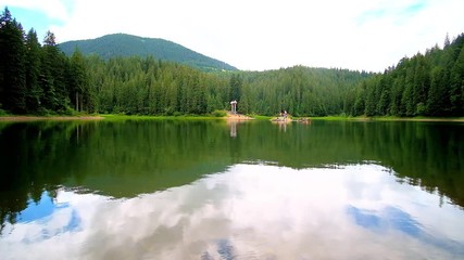 Poster - Enjoy the scenic Synevyr Lake, surrounded by green coniferous forests and Carpathian mountains, reflecting on clear water surface, Ukraine.