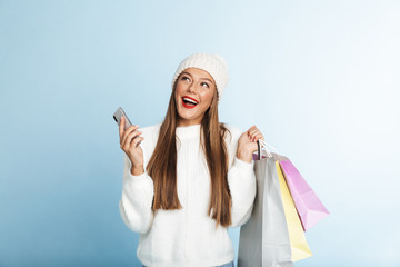 Wall Mural - Cheerful young woman wearing sweater standing