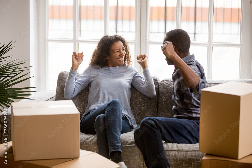 Happy African American couple in love celebrating moving in new house ...