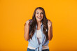 © Drobot Dean - Excited young woman posing isolated over yellow wall background.