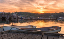 Early Morning Summer Sunrise Over Calm Water And John Boats Near A Working Lobster Wharf In Muscongus Bay, Maine