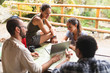 © Westend61 - Group of hikers sitting together planning a hiking route using map and laptop
