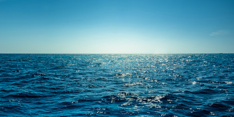 blue ocean panorama with sun reflection, the vast open sea with clear sky, ripple wave and calm sea 