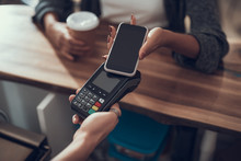 Lady with manicure holding smartphone and using contactless payment system