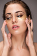 © LIGHTFIELD STUDIOS - elegant young woman with golden eye patches, isolated on grey