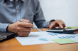 © Freedomz - Business man or accountant working Financial investment on calculator with calculate Analyze business and market growth on financial document data graph