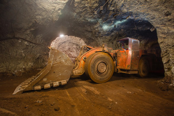 Underground gold iron ore mine shaft tunnel gallery passage with loading machine