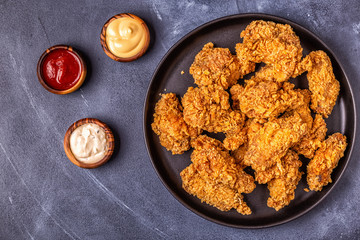 Fried chicken wings with various sauces.