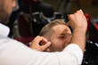 © serhiibobyk - Barber doing threading procedure of eyebrows in barbershop
