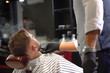© serhiibobyk - View from back of man on facial procedure in barber shop