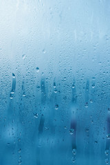 Window glass with high air humidity, large drops drip. Background of natural water condensation