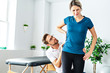 A Modern rehabilitation physiotherapy man at work with woman client working on hip