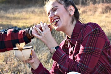 woman smiling in park and eating chocolate