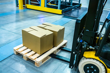 Forklift yellow. Warehouse automation. The boxes are on the forklift forks. Warehousing. Logistics in stock. Forklift rides through the warehouse.