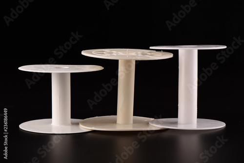 Fotografija Three plastic empty spools of tape or strips of cloth on a black