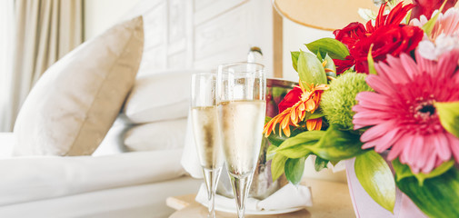 Two glasses of champagne in the upscale hotel room. Dating, romance, honeymoon, valentine, getaway concepts