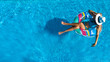 © Iuliia Sokolovska - Aerial top view of beautiful girl in swimming pool from above, relax swim on inflatable ring donut and has fun in water on family vacation