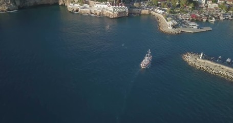Wall Mural - Forward aerial drone video follow boat pan right reveal marina harbor and Kaleici old city in Antalya, Turkey. 4k at 23.97fps