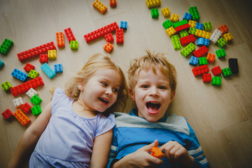 Poster - cute little boy and girl playing with plastic blocks