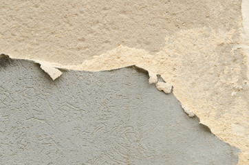 Cracked concrete wall with old layers of paint. Copy space