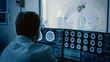 © Gorodenkoff - In Medical Laboratory Patient Undergoes MRI or CT Scan Process under Supervision of Radiologist, in Control Room Doctor Watches Procedure and Monitors with Brain Scans Results.