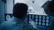 © Gorodenkoff - In Control Room Doctor and Radiologist Discuss Diagnosis while Watching Procedure and Monitors Showing Brain Scans Results, In the Background Patient Undergoes MRI or CT Scan Procedure.