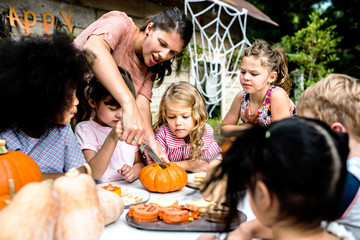 Wall Mural - Young kids carving Halloween jack-o'-lanterns