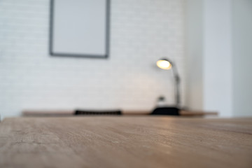 Wooden table with blurred white brick wall background