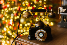 Analog Phone Is On The Table In The Library On A Blurred Background And Blurred Christmas Lights
