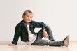 © master1305 - The portrait of cute little kid boy in stylish jeans clothes looking at camera against white studio wall. Kids fashion concept