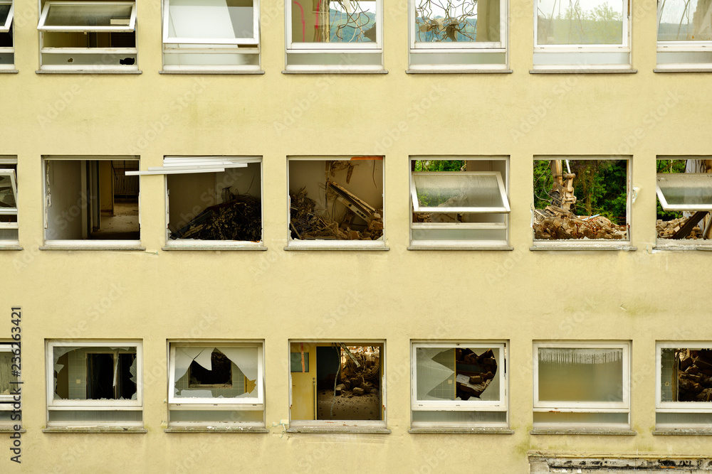 View through broken facade windows on demolishing operation of an old ...