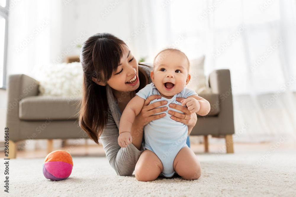 family and motherhood concept - happy smiling young asian mother with little baby at home - obrazy, fototapety, plakaty 