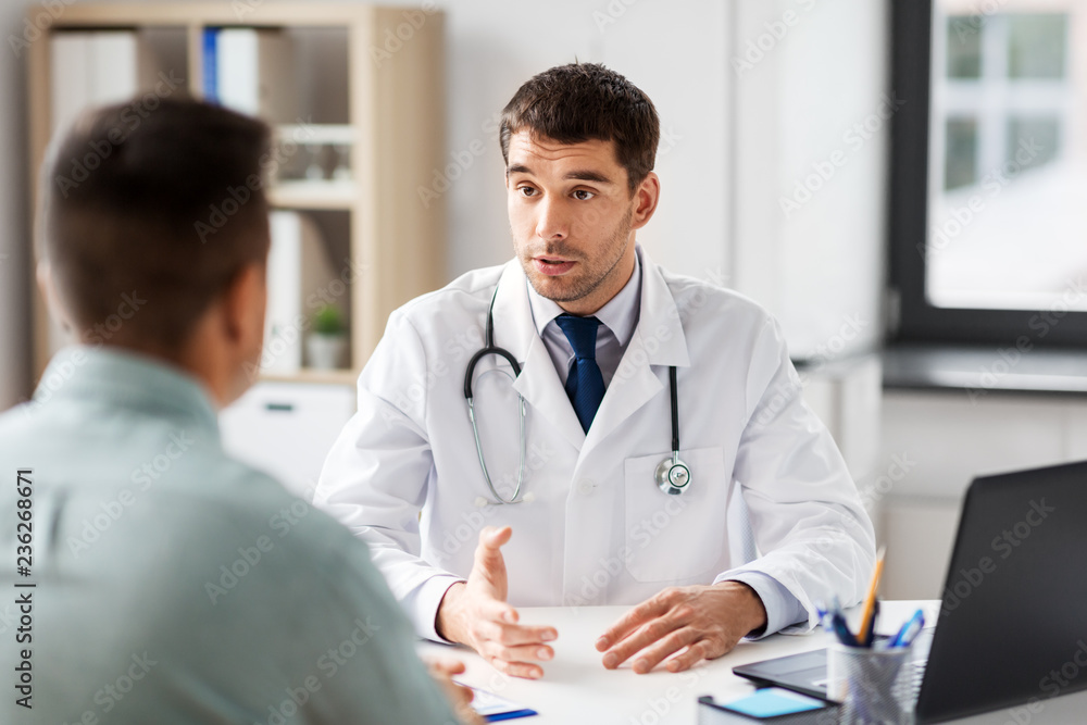 medicine, healthcare and people concept - doctor talking to male patient at medical office in hospital - obrazy, fototapety, plakaty 