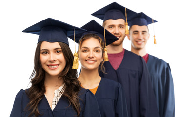 Wall Mural - education, graduation and people concept - group of happy graduate students in mortar boards and bachelor gowns over white background