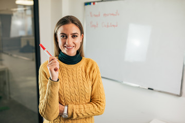 Portrait of happy young business woman with marker.