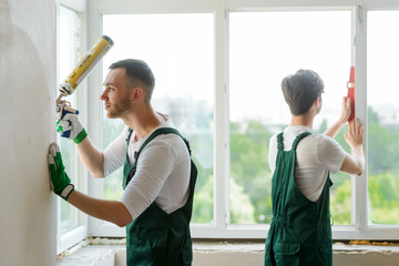 Two workers installing a window