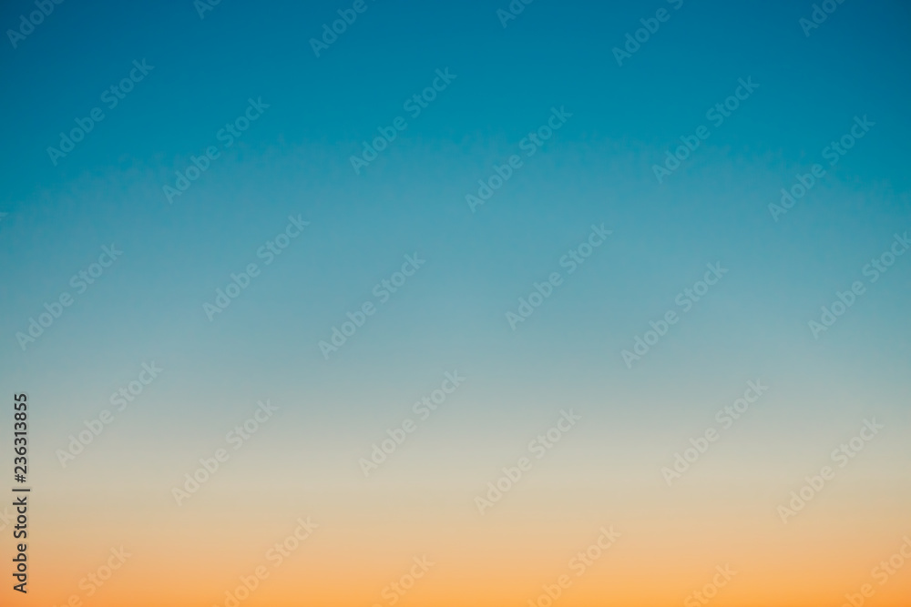 Predawn clear sky with orange horizon and blue atmosphere. Smooth orange blue gradient of dawn sky. Background of beginning of day. Heaven at early morning with copy space. Sunset, sunrise backdrop. - obrazy, fototapety, plakaty 