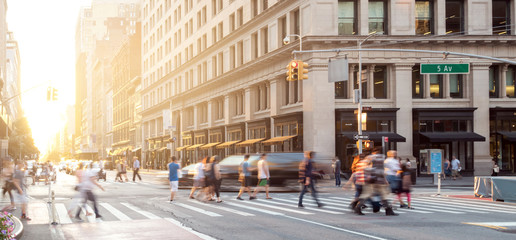 New York City street scene with crowds of people walking in Midtown Manhattan and sunlight background