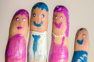 Four male fingers, which are painted under the little men. Close-up on a gray background.