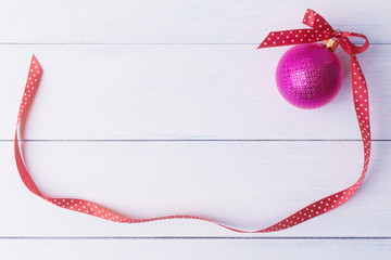 Christmas ball with long red ribbon.