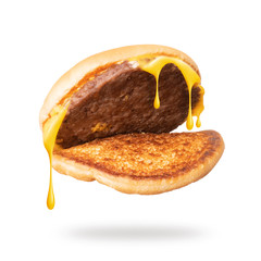 Wall Mural - Melted cheese flows from cheeseburger close-up on white background