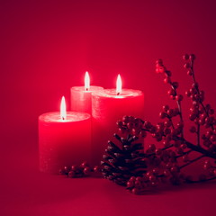 Wall Mural - Christmas, holiday composition. Xmas decorations, red berries, fir cones, red three candles on red background. Christmas, New Year, winter concept. copy space